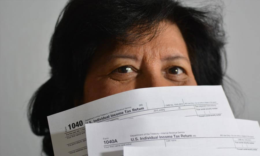 woman holding tax forms in front of her face