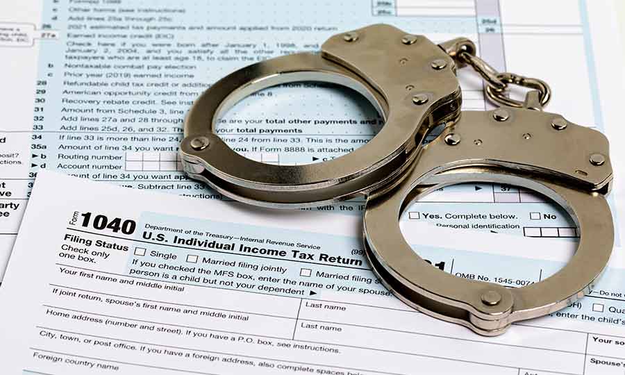 handcuffs laid on top of tax forms
